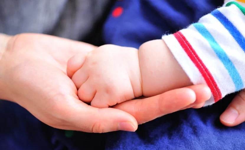 ママの手の上に赤ちゃんの手